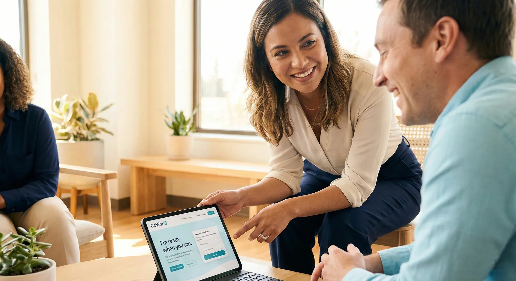 A team reviewing work together on a laptop in a bright office